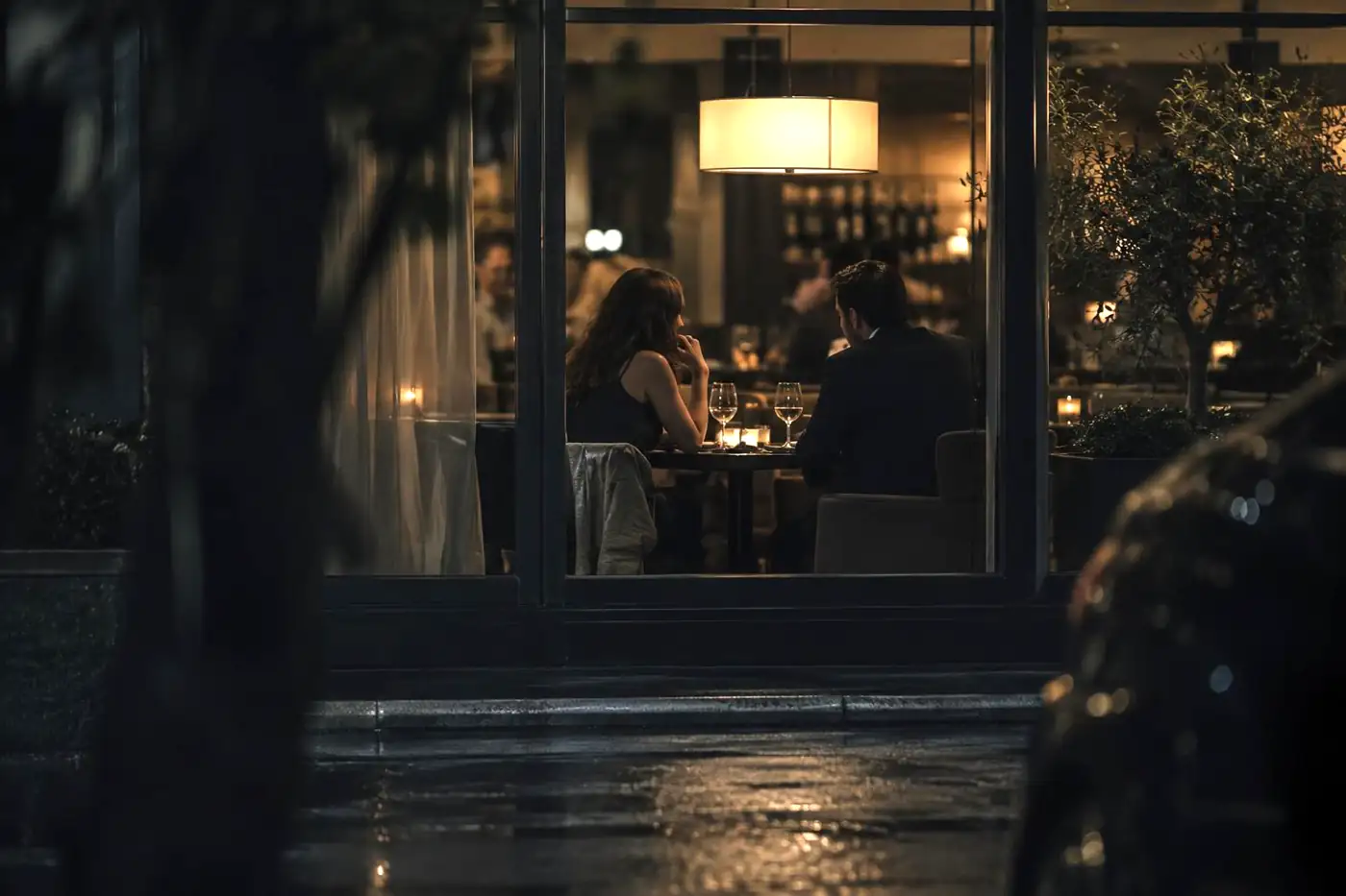 Discreet view through a restaurant window at night during an infidelity investigation